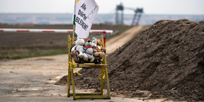 Zum Protest steht ein Stuhl mit Stofftieren am Rande des Braunkohletagebau Garzweiler