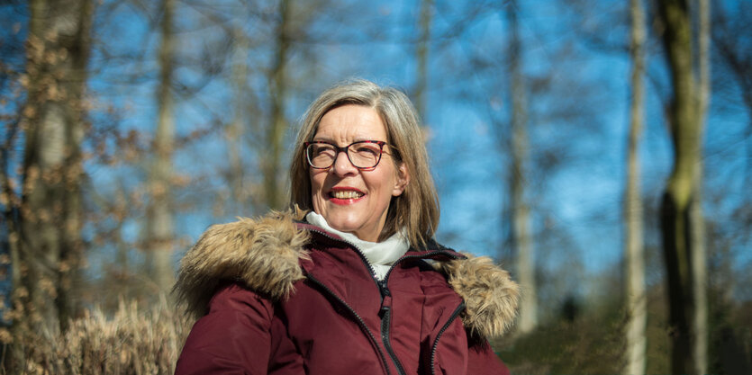 Eine Frau mit roter Jackel im Wald