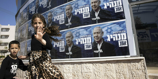 Kinder winken vor Wahlplakaten die Benjamin Netanyahu zeigen