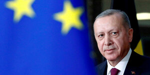 Der türkische Präsident Recep Tayyip Erdoğan neben einer EU Flagge