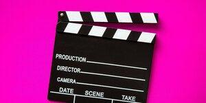 Filmklappe vor pinkem Hintergrund.