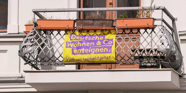 Ein Plakat des Volksbegehrens Deutsche Wohnen und Co Enteignen hängt an einem Berliner Balkon