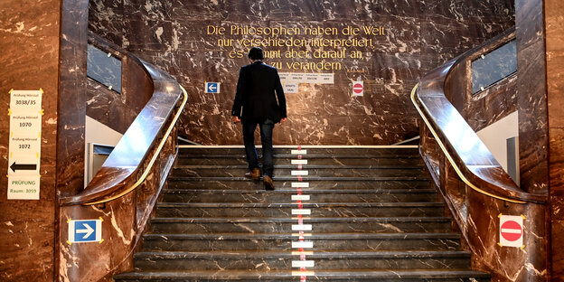 Ein Mensch geht eine Treppe hinauf in der Humboldtuniversität