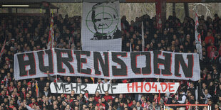 Fußballfans hatlen Transparent mit der Aufschrift "Hurensohn" hoch