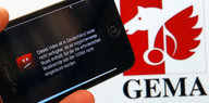 Ein Handy vor dem Gema-Logo zeigt ein gesperrtes Youtube-Video