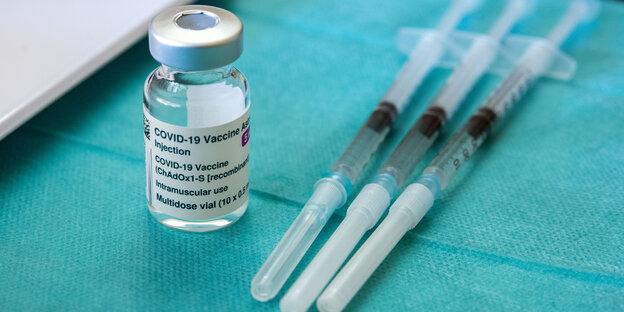 Ein Fläschen mit Astra-Zeneca Impfstoff, daneben Spritzen