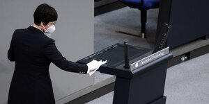 Eine Mitarbeiterin reinigt das Rednerpult im Plenarsaal des Deutschen Bundestages