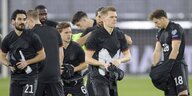 Deutsche Nationalspieler stehen zusammen und wechseln ihre Trikots
