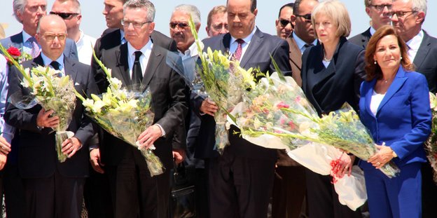 Politiker mit Blumensträußen