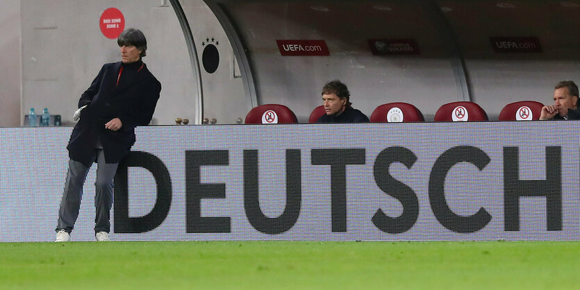 Joachim Löw lehnt an einer Bande, auf der "Deutsch" steht