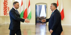 Der polnische Präsident Andrzej Duda und der ungarische Premierminister Voktor Orban strecken die Hände zur Begrüßung aus