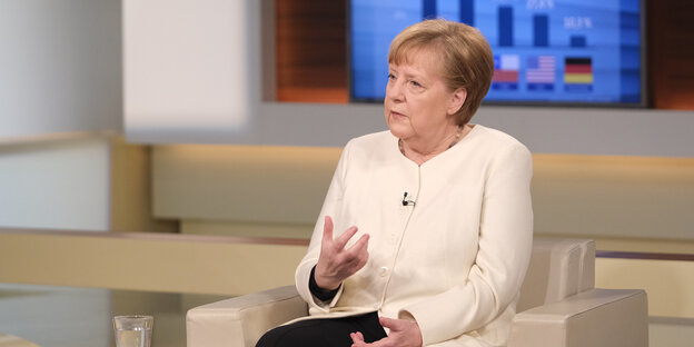 Angela Merkel sitzt auf einem Talkshow-Sessel und spricht