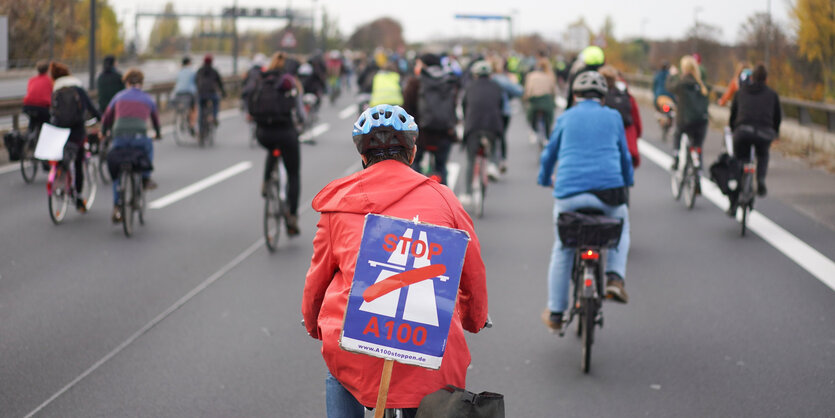 Fahrrad Demo auf der A100. Ein Schild mit durchgestrichenem Autobahn-Symbol fordert den Stopp der A100