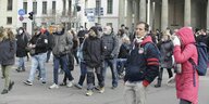 Menschen nehmen an einer rechtsextremen Kundgebung teil, ein Mann mit Käppi, Brille und Umhängetasche ist mutmaßlicher AfD-Mitarbeiter