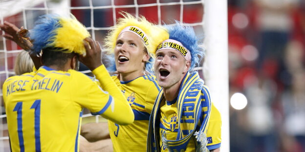 drei schwedische U21-Spieler mit gelb-blauen Perücken feiern ihren EM-Sieg