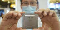 Ein Mitarbeiter präsentiert einen in China entwickelten Chip an einem Messestand in Shanghai