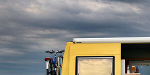 Ein gelber Campingbus mit Fahrrad