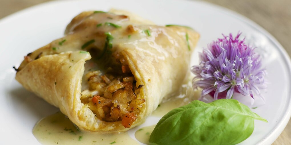 Ein veganes Filet Wellington, also Blätterteig mit Füllung, liegt auf einem Teller