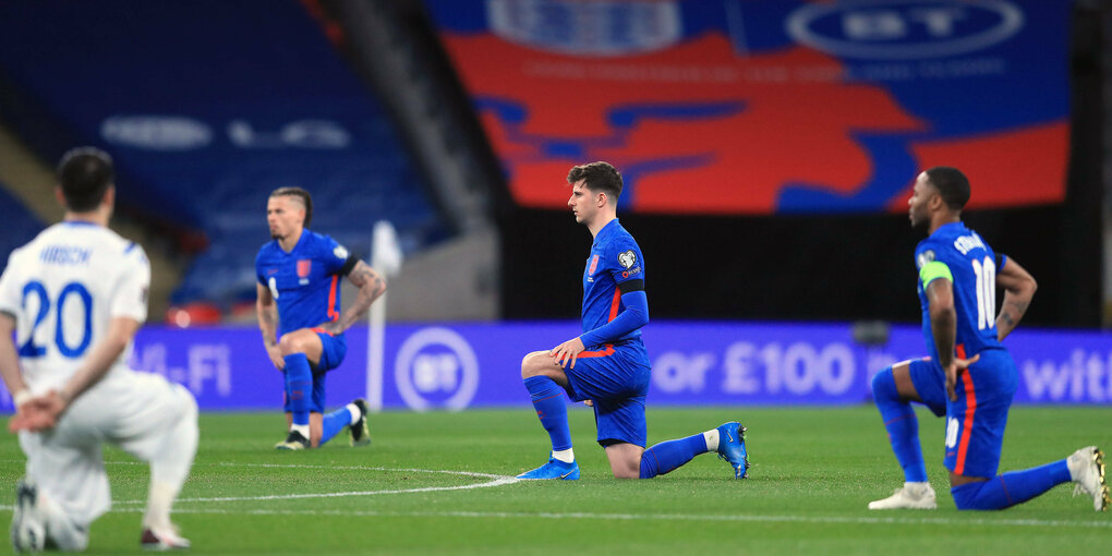 Vier Nationalspieler knieen auf dem Fußballfeld des Wembley Stadions