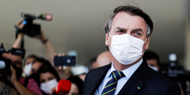 Brasiliens Präsident Jair Bolsonaro mit Mund-Nasenschutz vor JournalistInnen