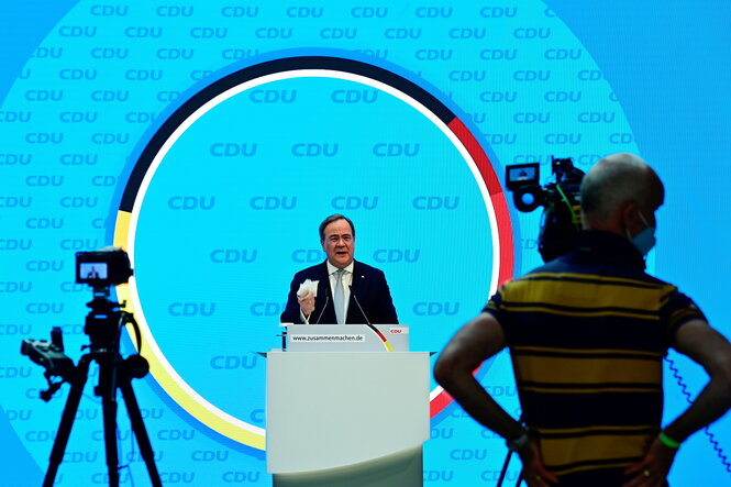 Laschet vor blauem Hintergrund mit CDU Buchstaben im Kreis