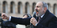Armeniens Regierungschef Nikol Paschinjan streckt seine Faust aus und schreit in ein Mikrofon während einer Kundgebung