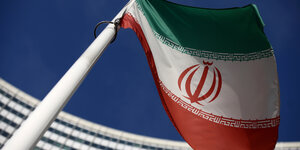 Die iranische Flagge weht vor einem großen Gebäude