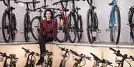 Marie Viertmann sitzt in einem Fahrradgeschäft vor ausgestellten Modellen – sie gehört zu den wenigen Reparateurinnen der Fahrradbranche