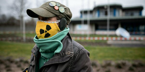 Frau mit Maske mit Atom-Symbol