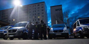 Das Bild zeigt mehrere Autos der Bundespolizei in der Morgendämmerung vor Plattenbauten in Berlin-Lichtenberg.