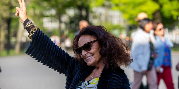 Designerin Diane von Furstenberg streckt die Hand zum Peace-Zeichen