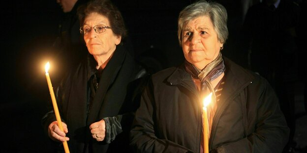 Zwei Frauen halten Kerzen in den Händen