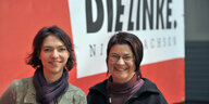 Zwei Frauen vor einer roten Wand mit dem Schriftzug der Partei Die Linke
