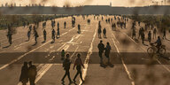 Menschen auf der Landebahn des ehemaligen Flughafens Tempelhof (Tempelhofer Feld) im Sonnenuntergang