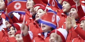 Nordkoreanische Sportfans schwenken Fähnchen