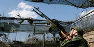 Ein Soldat richtet ein Maschinengewehr in Richtung Himmel
