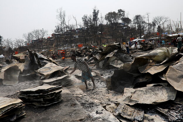 Mann steht in den Überresten der vom Brand zerstörten Camps.