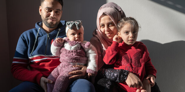Karim, seine Frau und zwei Kinder auf dem Schoss