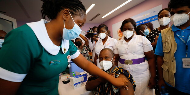 Eine medizinische Mitarbeiterin erhält in Accra, Ghana eine Covid-19 Impfung