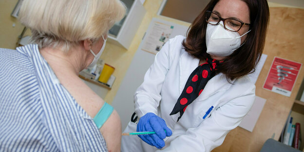 Hausärztin impft in ihrer Praxis eine Patientin gegen das Coronavirus