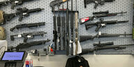 An einer Verkaufswand hängen zahlreiche Gewehre