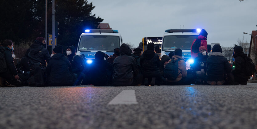 Menschen sitzen auf eienr Straße