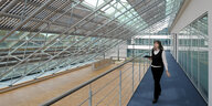 Eine Frau geht durch die Forschungseinrichtung "GFK Valley Stade", zu sehen ist, dass auf dem Dach Solarpanels angebracht sind