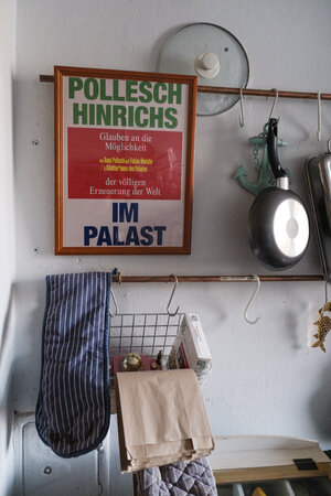 Küchenutensilien hängen an der Küchenwand sowie ein gerahmtes Bild mit Aufschrift "Pollesch Hinrichs - im Palast" Küchenutensilien hängen an der Küchenwand sowie ein gerahmtes Bild mit Aufschrift "Pollesch Hinrichs - im Palast"
