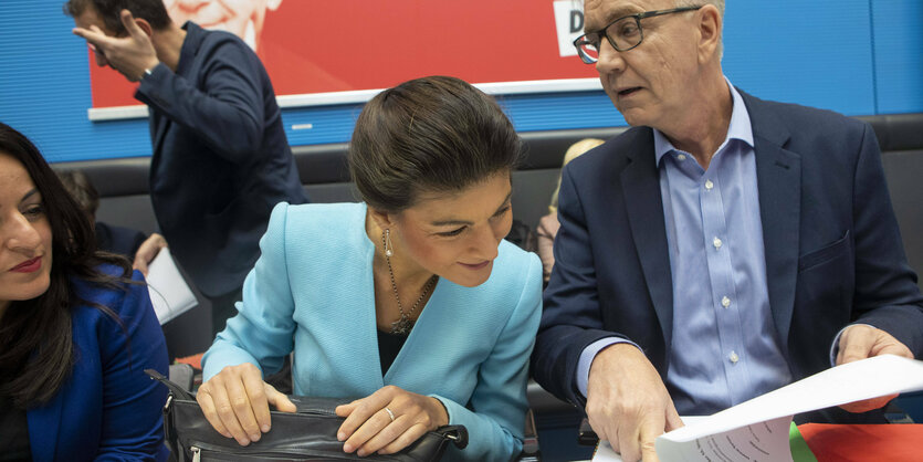 Sahra Wagenknecht blickt in Unterlagen von Dietmar Bartsch