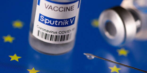 Spritze und Sputnik V Impfstoff-Ampullen auf EU Symbol