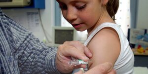Ein Mädchen wird gegen Kinderkrankheiten geimpft
