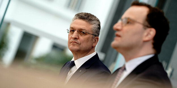 Wieler und Spahn sitzen nebeneinander, Spahn vorne ist unscharf, Wieler im Hintergrund im Fokus. Wieler und Spahn sitzen nebeneinander, Spahn vorne ist unscharf, Wieler im Hintergrund im Fokus.