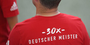 Ein Mann von hinten: auf dem T-Shirt steht "30x Deutscher Meister"