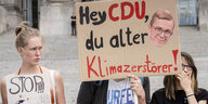 Demonstranten halten ein Plakat mit der Aufschrift "Hey CDU, du alter Klimazerstörer" hoch